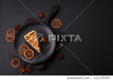 Delicious fresh cheesecake caramel peanut cake with cream and nuts on a ceramic plate on a dark concrete background 122276447