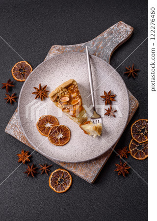Delicious fresh cheesecake caramel peanut cake with cream and nuts on a ceramic plate on a dark concrete background Delicious fresh cheesecake caramel peanut cake with cream and nuts on a ceramic plate on a dark concrete background 122276460