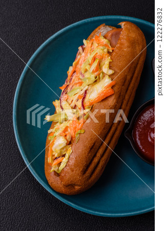 Hotdog with grilled sausage with cabbage, carrots and onions 122276832