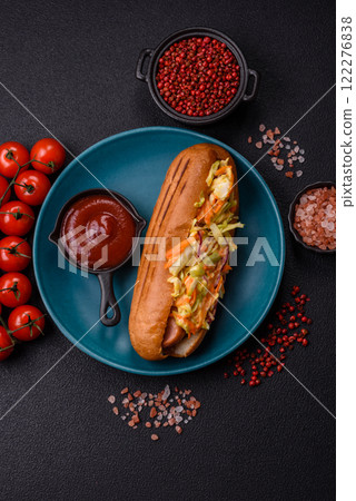 Hotdog with grilled sausage with cabbage, carrots and onions 122276838