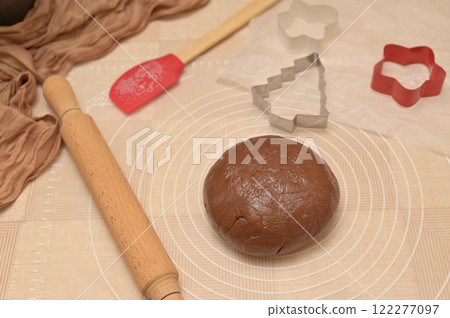 Christmas homemade baking, brown cocoa dough for baking gingerbread, shaped cutter, silicone spatula and rolling pin on the table 122277097