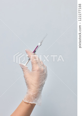 A healthcare professional giving an injection with a gloved hand for safety and hygiene A healthcare professional giving an injection with a gloved hand for safety and hygiene 122277188