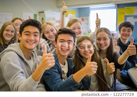 Students in a classroom are sitting at desks giving a thumbs up 122277729