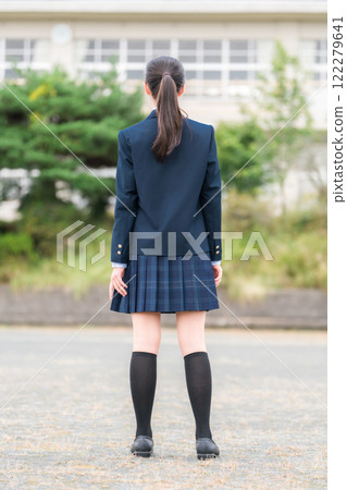 Back view of junior high school, high school, and elementary school students in uniform standing in front of a school building Back view of junior high school, high school, and elementary school students in uniform standing in front of a school building 122279641