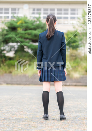 Back view of junior high school, high school, and elementary school students in uniform standing in front of a school building Back view of junior high school, high school, and elementary school students in uniform standing in front of a school building 122279827