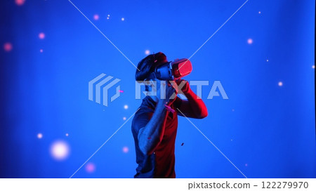 Gamer boxing and punching floating box while wearing VR glasses. Apparatus. 122279970