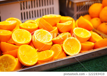 Freshly cut orange halves displayed at market, showcasing vibrant colors and juicy interiors. Perfect for refreshing drink or healthy snack Freshly cut orange halves displayed at market, showcasing vibrant colors and juicy interiors. Perfect for refreshing drink or healthy snack 122283410