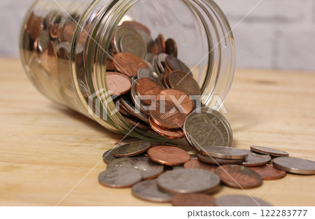 Glass Jar of American Coins on Wooden Table Glass Jar of American Coins on Wooden Table 122283777
