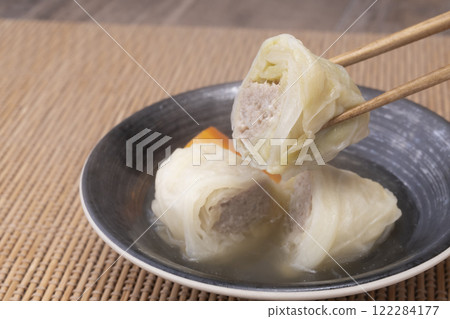 Picking up Japanese-style cabbage rolls stewed in bonito broth with chopsticks Picking up Japanese-style cabbage rolls stewed in bonito broth with chopsticks 122284177