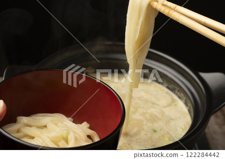 The final dish of the hot pot: Picking up the udon noodles with chopsticks. 122284442