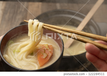 The final dish of the hot pot: Picking up the udon noodles with chopsticks 122284511