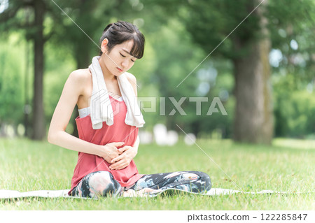 Young woman suffering from abdominal pain and menstrual cramps (yoga, exercise) 122285847