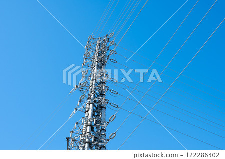 A power transmission tower towering in a clear blue sky: E-1 cylinder A power transmission tower towering in a clear blue sky: E-1 cylinder 122286302