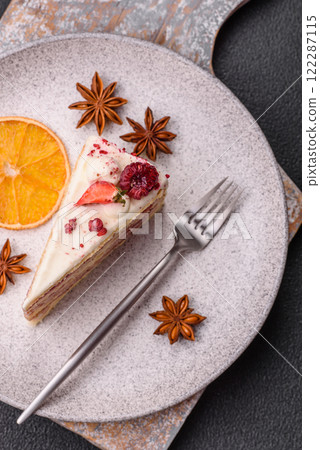 Piece of sweet layer cake with white cream, raspberries and strawberries 122287115