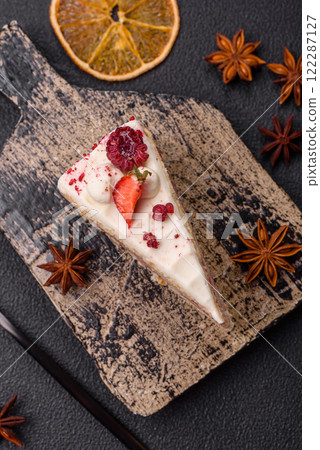 Piece of sweet layer cake with white cream, raspberries and strawberries 122287127