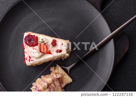 Piece of sweet layer cake with white cream, raspberries and strawberries 122287138