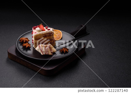 Piece of sweet layer cake with white cream, raspberries and strawberries 122287140