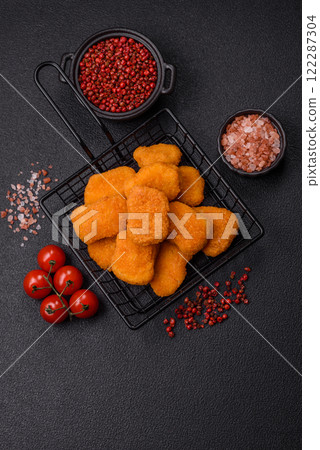 Delicious fresh crispy chicken nuggets on a dark concrete background 122287304