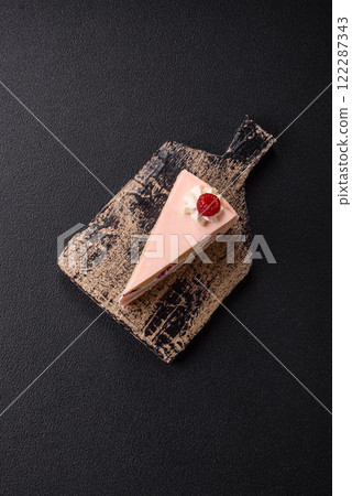 Piece of sweet cake with pink cream with raspberry flavor, with shortbread, cheesecake 122287343