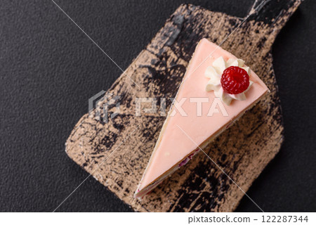 Piece of sweet cake with pink cream with raspberry flavor, with shortbread, cheesecake 122287344