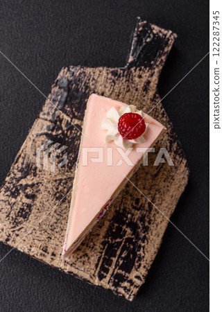 Piece of sweet cake with pink cream with raspberry flavor, with shortbread, cheesecake 122287345