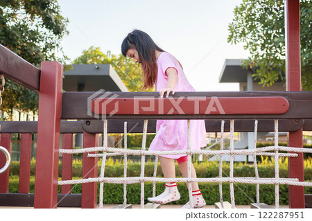 Cute asian girl playing in the playground Cute asian girl playing in the playground 122287951