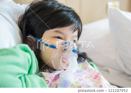Sick little asian girl inhalation with nebulizer for respiratory treatment 122287952