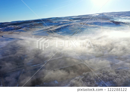 Aerial view of misty countryside hills at wintertime, morning fog above Aerial view of misty countryside hills at wintertime, morning fog above 122288122