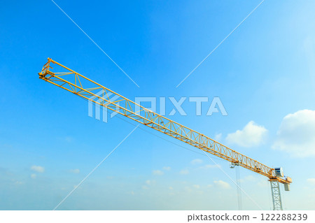 Industrial construction crane with blue sky background at building site 122288239