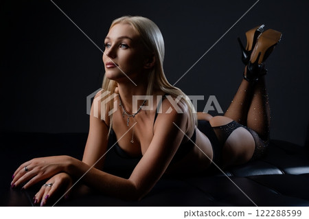 Elegant model posing in stylish lingerie with dramatic lighting in a studio 122288599
