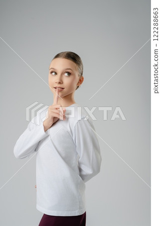 Girl practicing dance with a playful pose in a studio setting Girl practicing dance with a playful pose in a studio setting 122288663