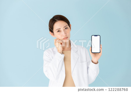 Woman in white coat, smartphone, worries 122288768