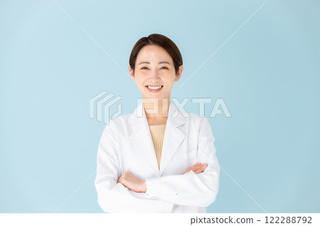 Woman in white coat with arms crossed 122288792