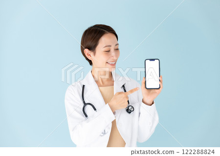 Woman in white coat, stethoscope, smartphone, smiling 122288824