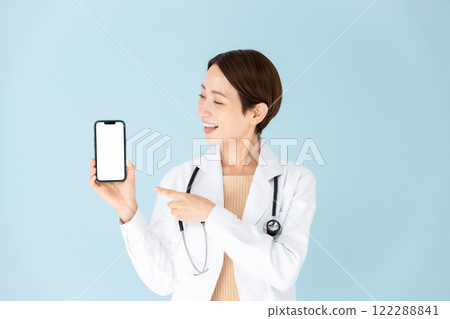 Woman in white coat, stethoscope, smartphone, smiling 122288841
