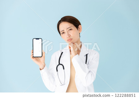 穿白大褂、聽診器、智慧型手機、擔心的女人 穿白大褂、聽診器、智慧型手機、擔心的女人 122288851