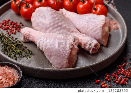 Raw chicken legs with salt, spices, herbs and tomatoes 122288863