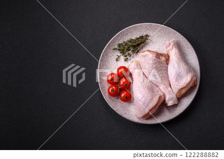 Raw chicken legs with salt, spices, herbs and tomatoes Raw chicken legs with salt, spices, herbs and tomatoes 122288882