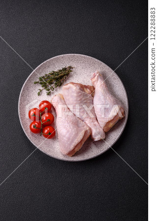 Raw chicken legs with salt, spices, herbs and tomatoes Raw chicken legs with salt, spices, herbs and tomatoes 122288883