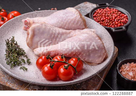 Raw chicken legs with salt, spices, herbs and tomatoes 122288887
