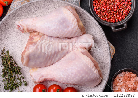 Raw chicken legs with salt, spices, herbs and tomatoes 122288888
