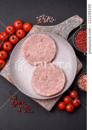 Raw chicken burger cutlet with salt, spices and herbs 122289109
