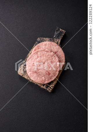 Raw chicken burger cutlet with salt, spices and herbs 122289124