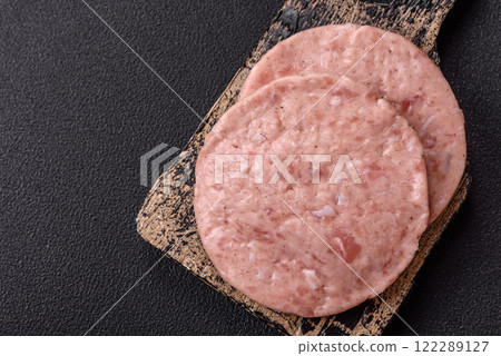 Raw chicken burger cutlet with salt, spices and herbs Raw chicken burger cutlet with salt, spices and herbs 122289127
