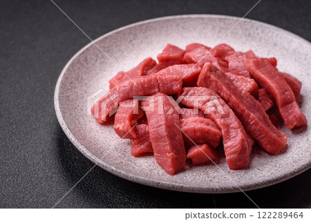 Juicy raw beef cut into slices with salt and spices Juicy raw beef cut into slices with salt and spices 122289464