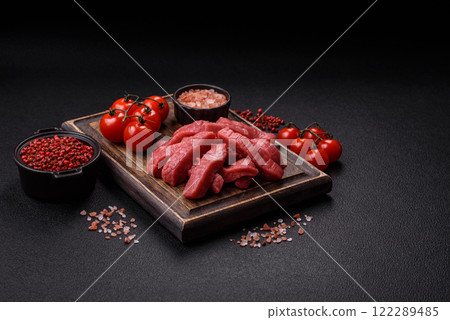 Juicy raw beef cut into slices with salt and spices Juicy raw beef cut into slices with salt and spices 122289485