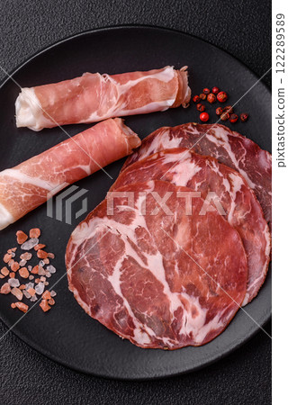 Antipasto jamon, prosciutto, sausage, sliced with tomatoes, salt and spices 122289589