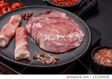 Antipasto jamon, prosciutto, sausage, sliced with tomatoes, salt and spices Antipasto jamon, prosciutto, sausage, sliced with tomatoes, salt and spices 122289590