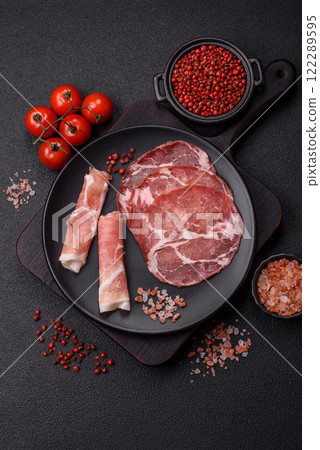 Antipasto jamon, prosciutto, sausage, sliced with tomatoes, salt and spices Antipasto jamon, prosciutto, sausage, sliced with tomatoes, salt and spices 122289595