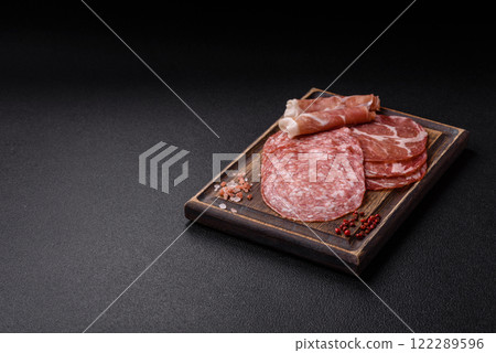 Antipasto jamon, prosciutto, sausage, sliced with tomatoes, salt and spices Antipasto jamon, prosciutto, sausage, sliced with tomatoes, salt and spices 122289596